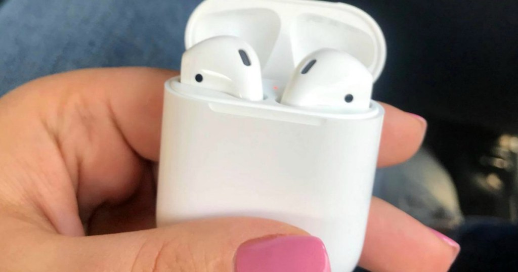 Woman holding Apple Airpods in charging case