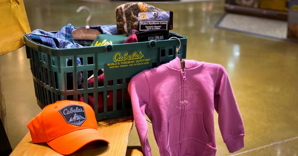 Cabela's shopping basket full of items with Cabela's hat and hoodie