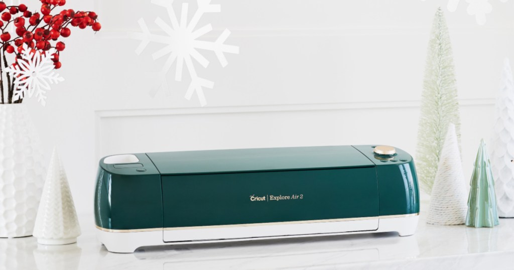 green and white cricut explorer air 2 on desk with christmas decoratiosn