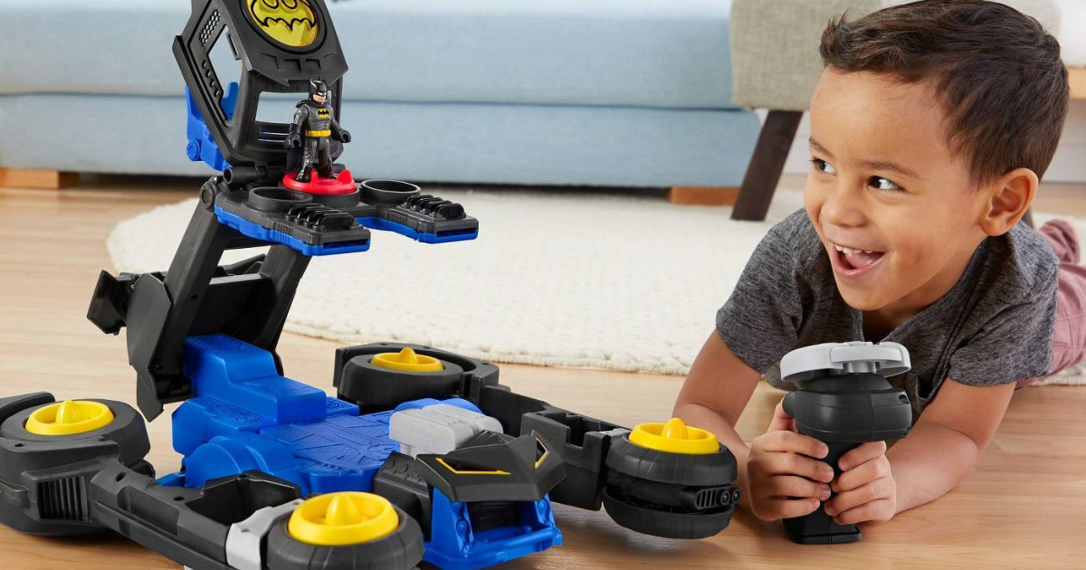 boy playing with dc super friends thransforming batmobile vehicle