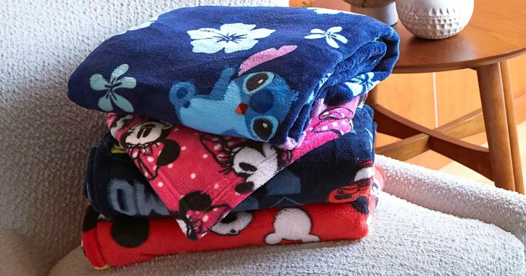 Disney Plush Blankets folded in stack on armchair