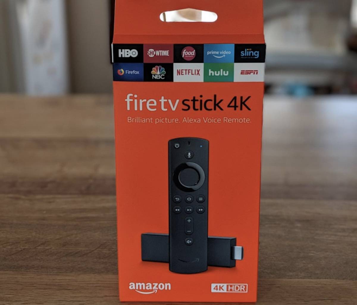 Amazon Fire TV Stick 4K in orange packaging sitting on a tabletop