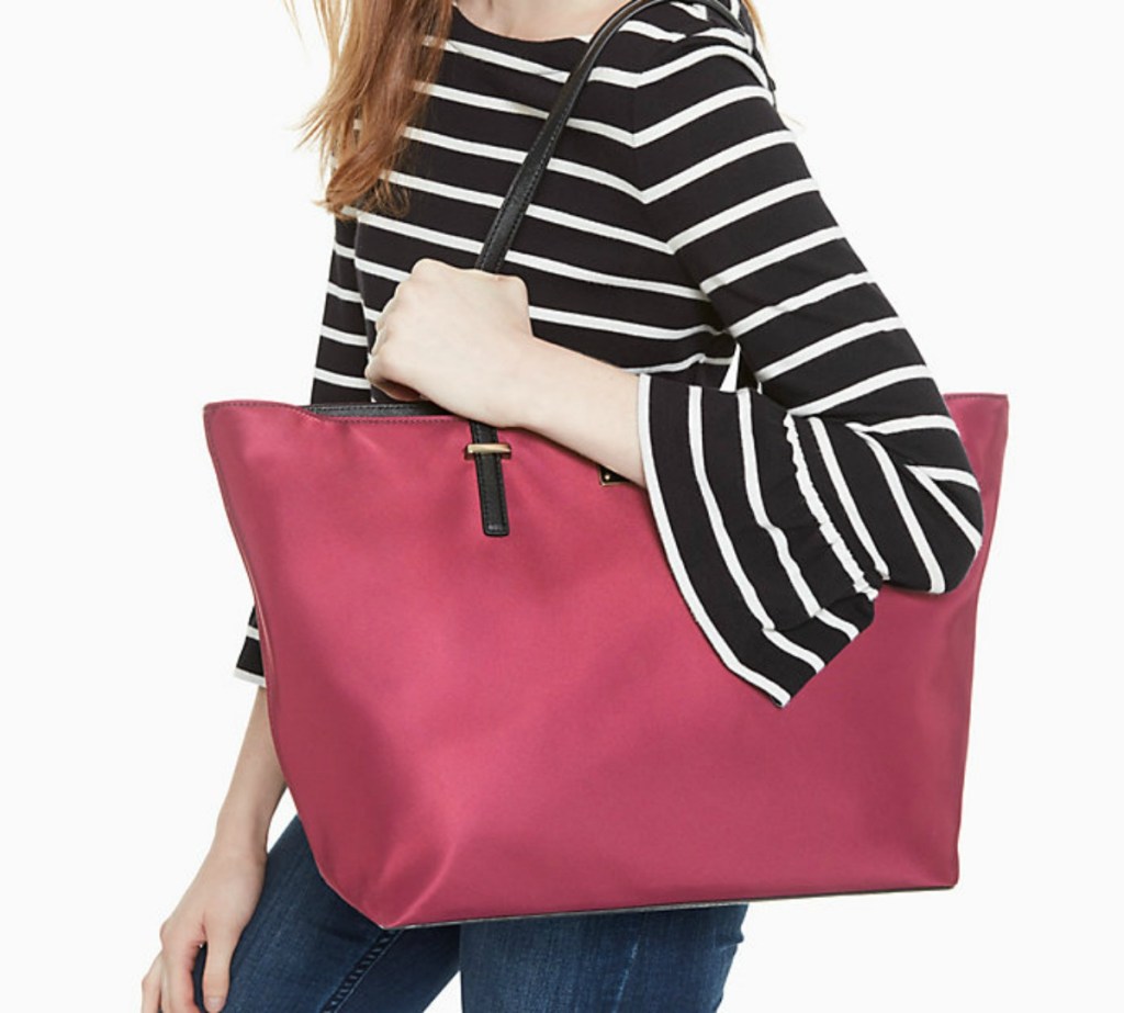 woman in striped top carrying large red bag