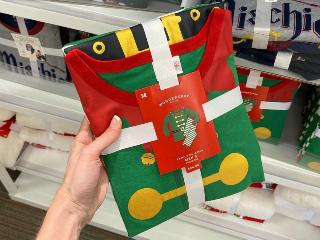 Hand holding elf themed pajamas in package at Target