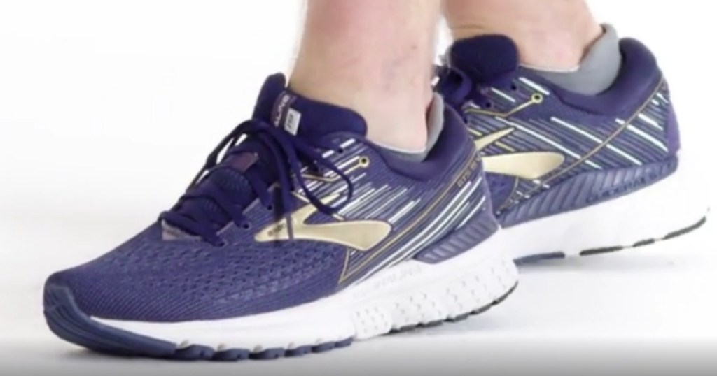 Man wearing navy and gold Brooks running shoes
