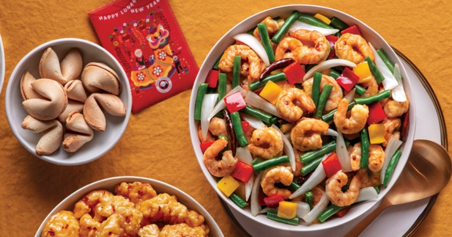 Lunar New Year red enveope, shrimp, vegetables and rice in a big bowl next to fortune cookies