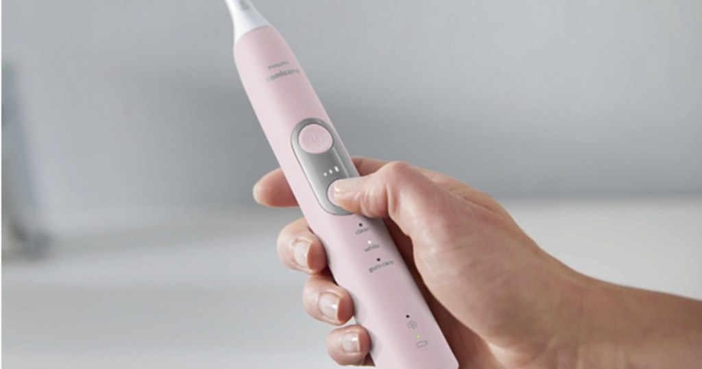 hand holding up phillips sonicare toothbrush