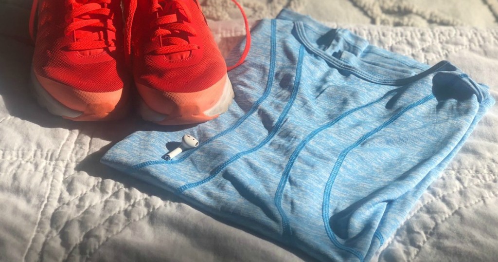 Reebok Performance Tee next to running shoes and earpods