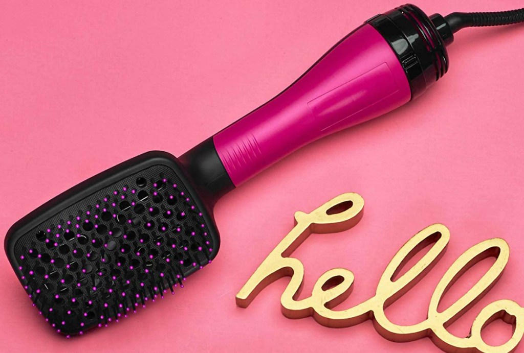 Pink and black styling paddle brush on pink background