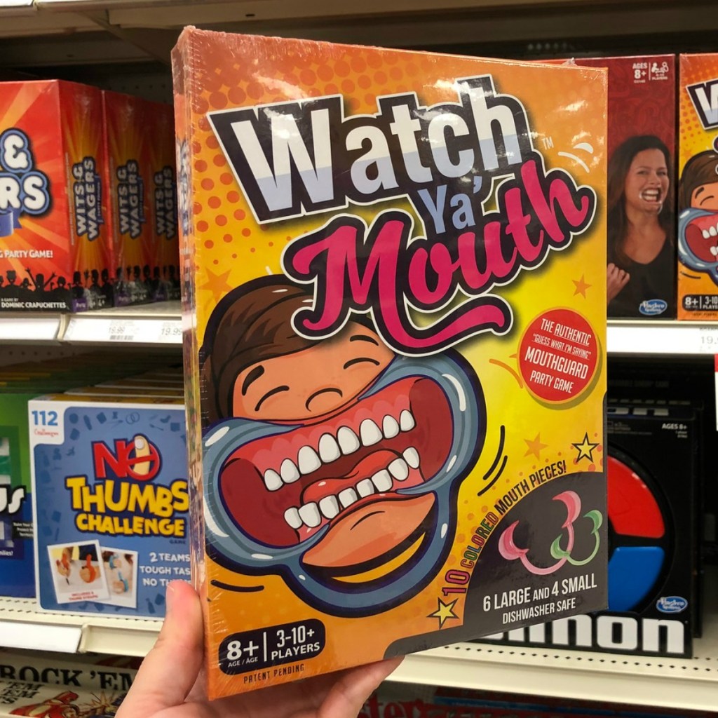 Woman holding the Watch Ya Mouth Party game in package, in hand