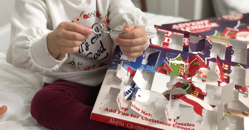 kid playing with metal puzzle with advent calendar on lap 
