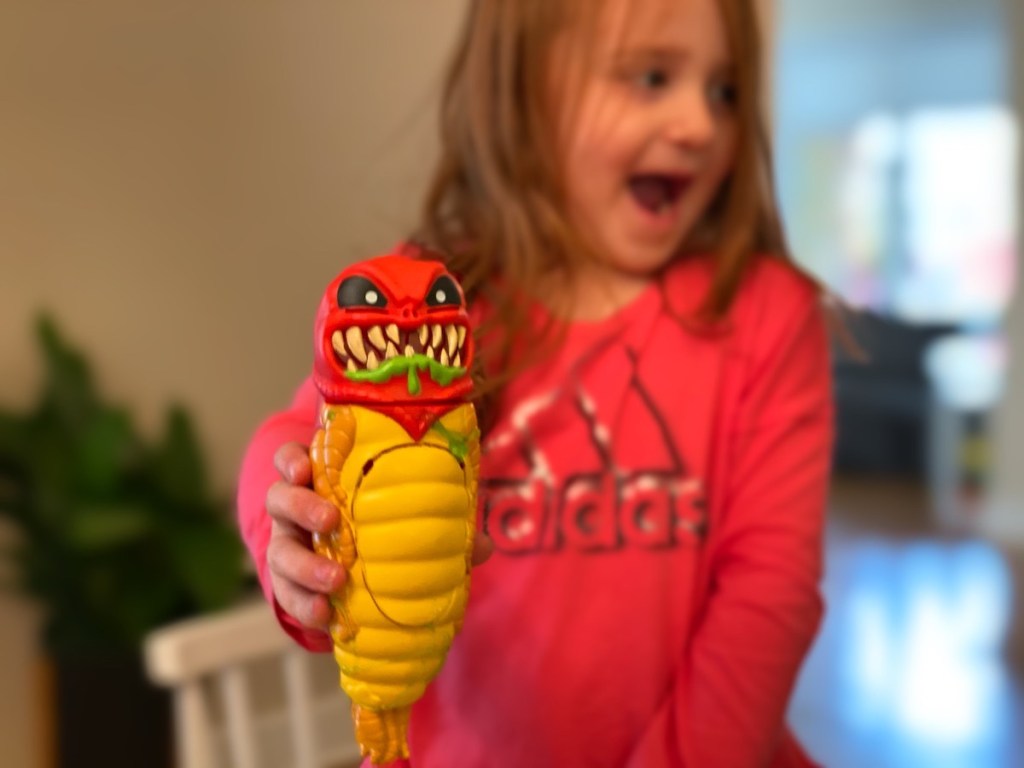 girl holding red and yellow alien 