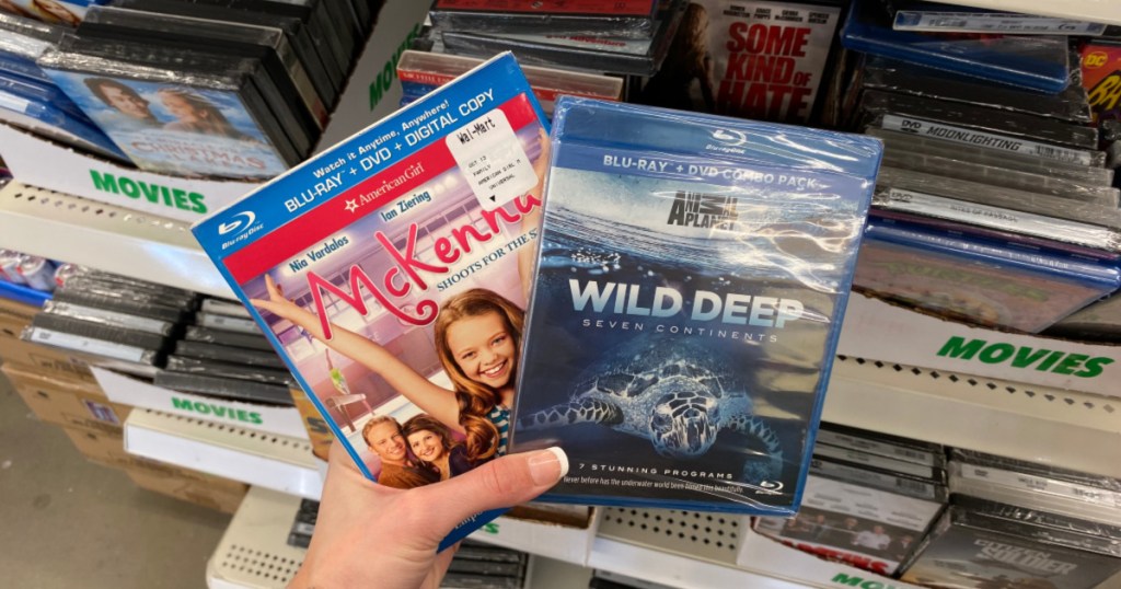 hand holding up two blu-ray movies at dollar tree