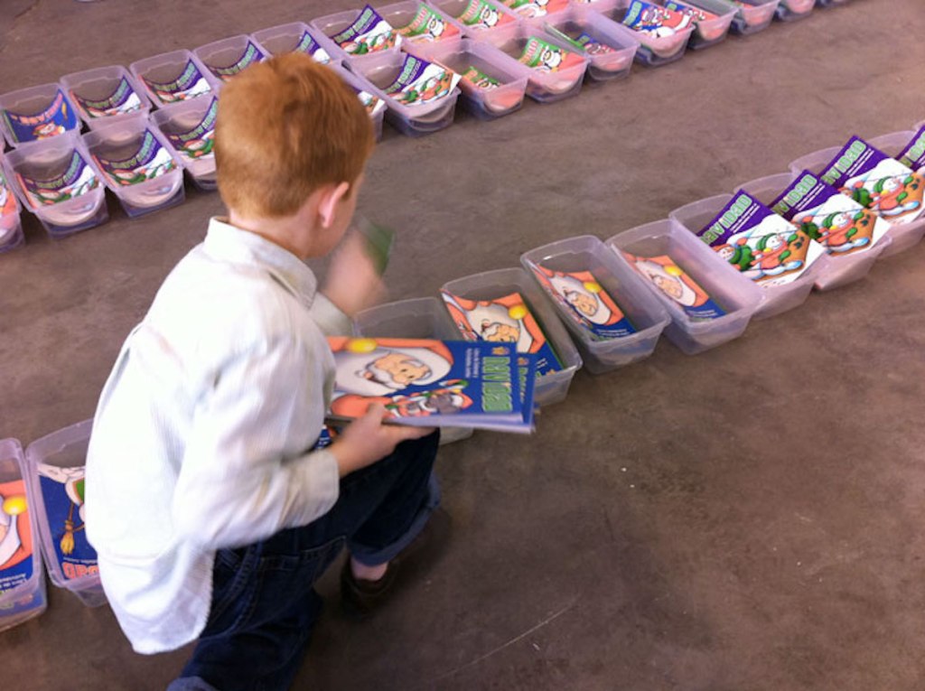 boy filling clear totes with christmas stuff