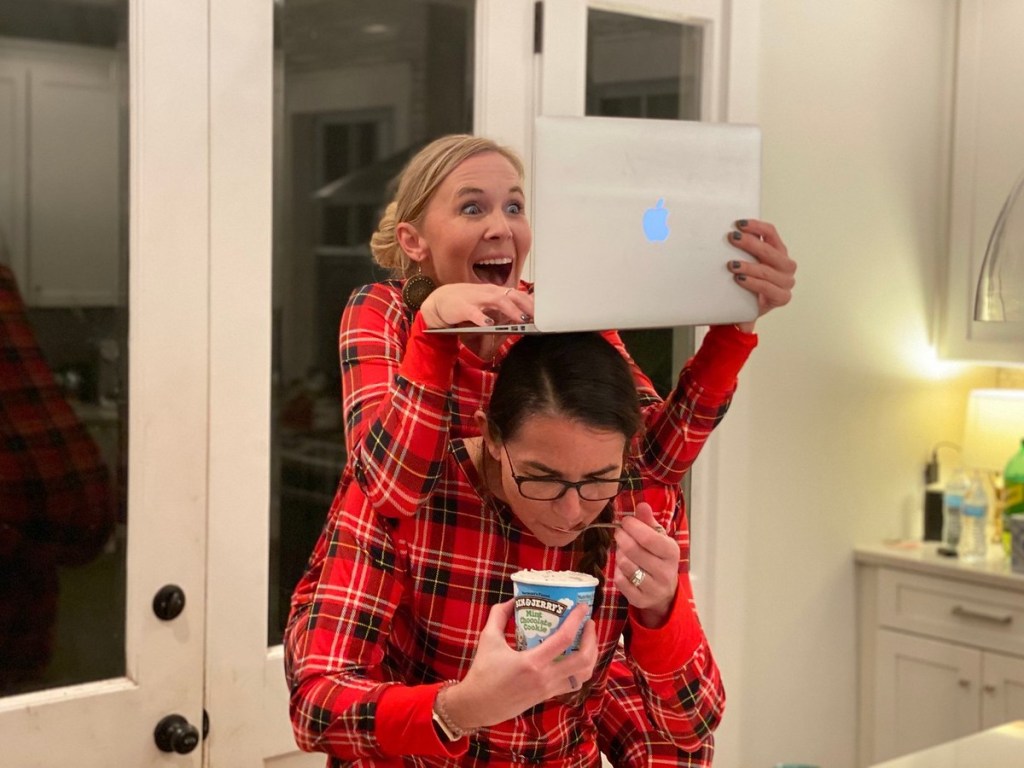 woman eating ice cream under woman with Macbook