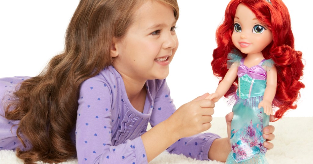 girl playing with disney ariel doll