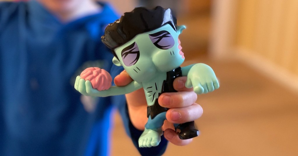 kid hand holding blue farting butthead toy