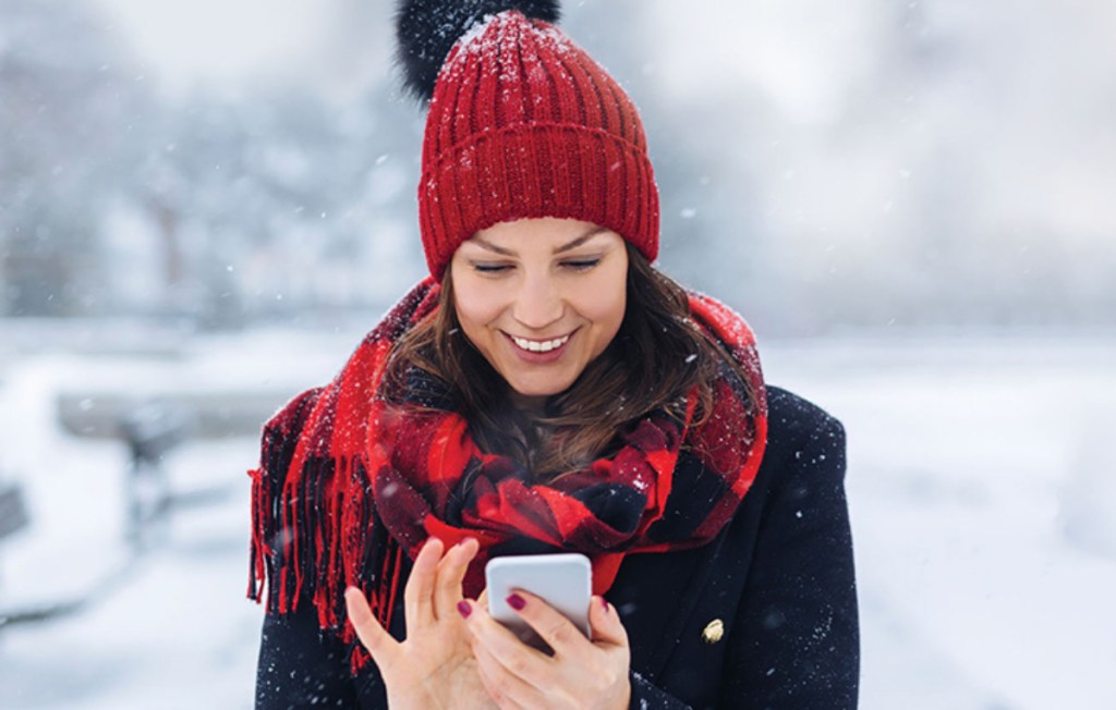 woman dressed for winter looking at smartphone