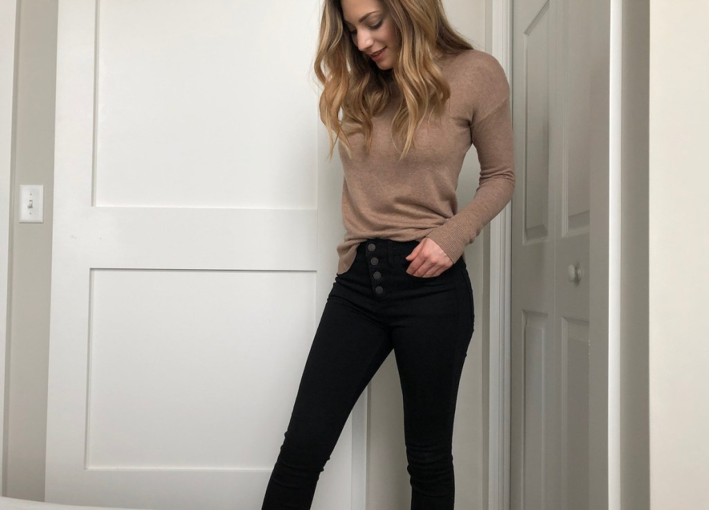 woman wearing black jeans and brown sweater