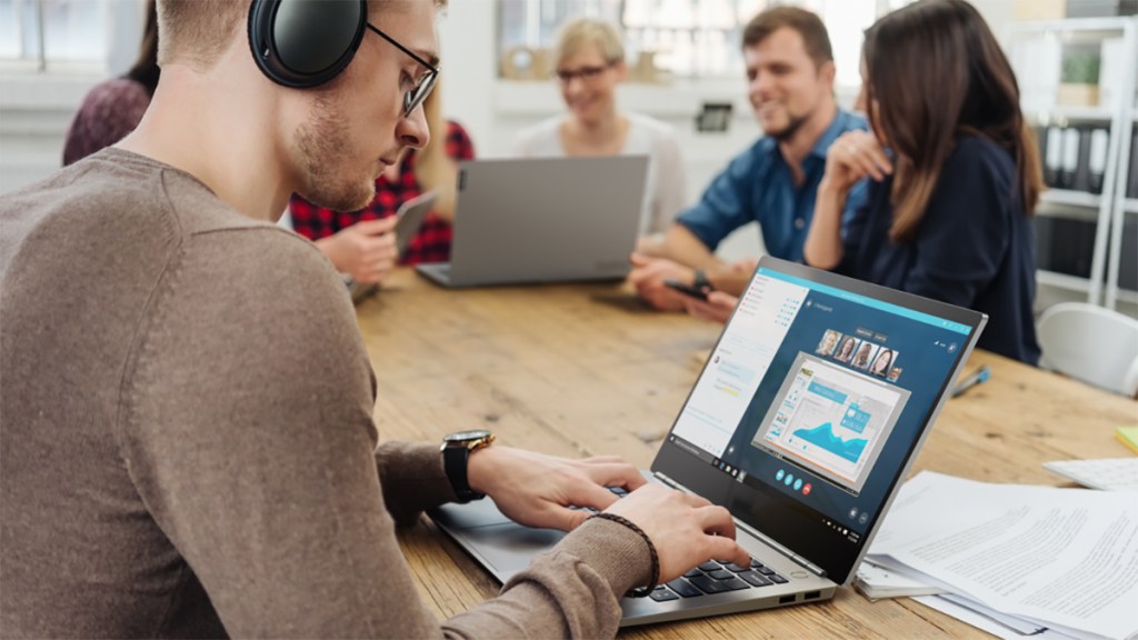 man sitting on table using laptop