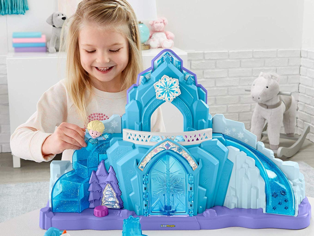 little girl playing with frozen ice castle and figures