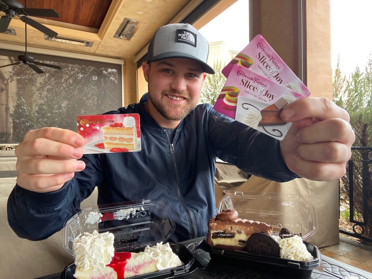 man holding Cheesecake Factory gift cards