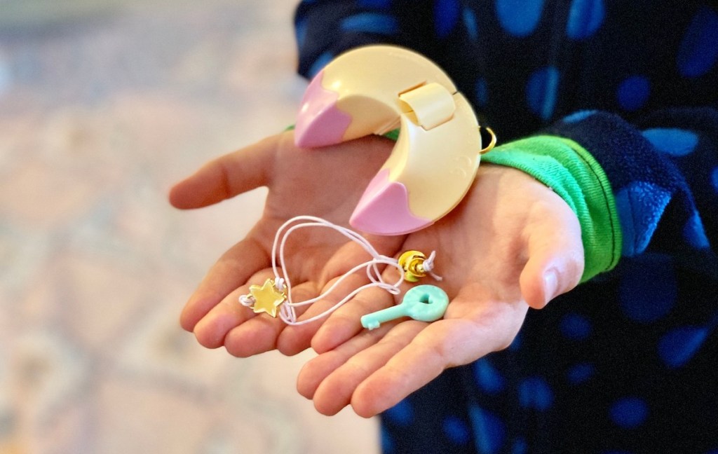 mini fortune cookie in hands with bracelets and key