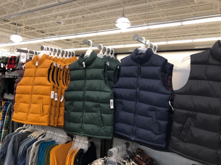 old navy mens puffer vests hanging in store