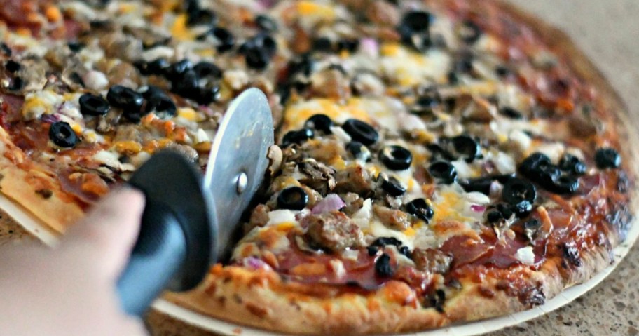 someone cutting pizza up