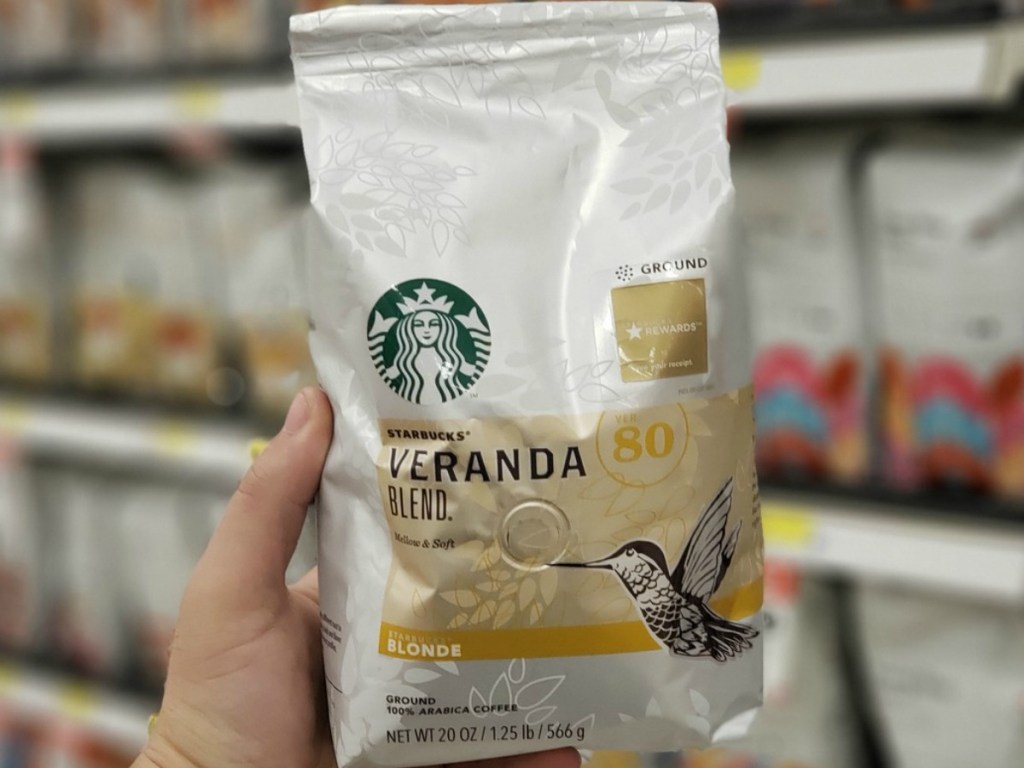 hand holding bag of coffee by store display