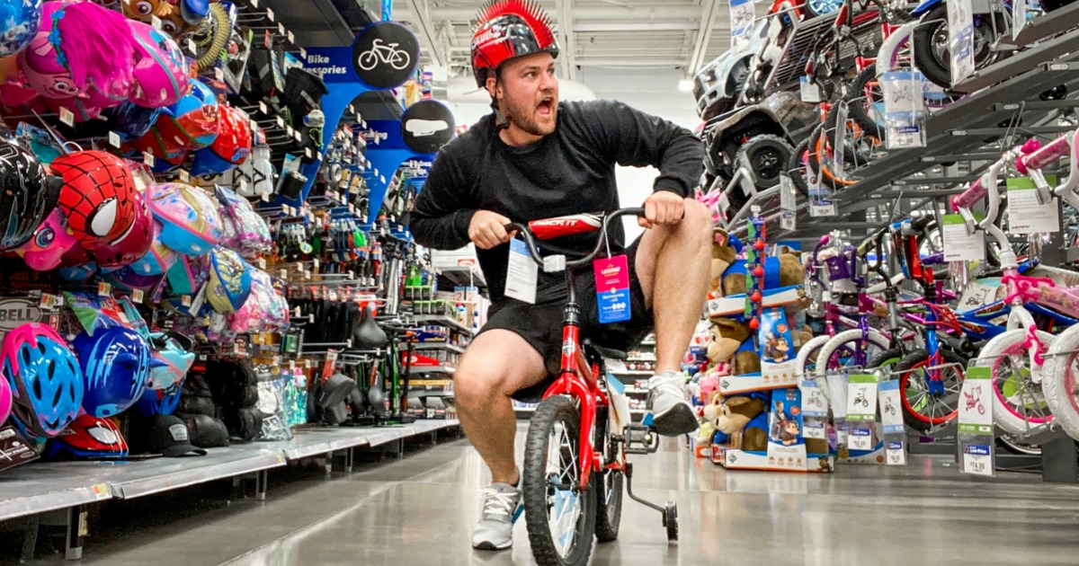 man wearing bike helmet riding bike in Walmart store