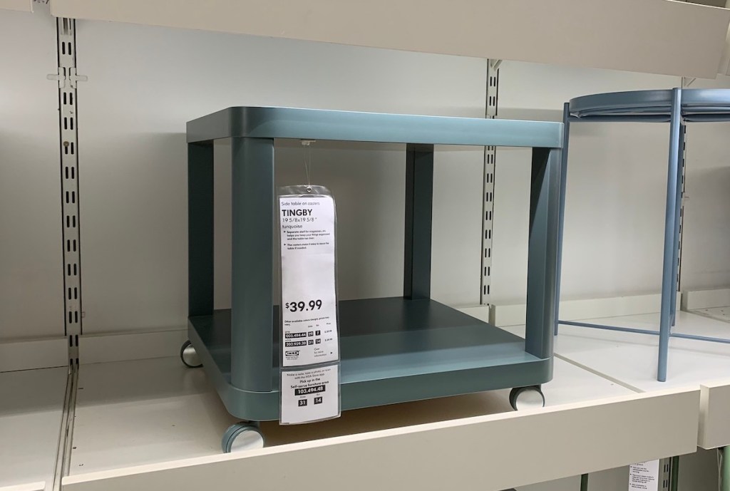 blue table with wheels sitting on top of store shelf 