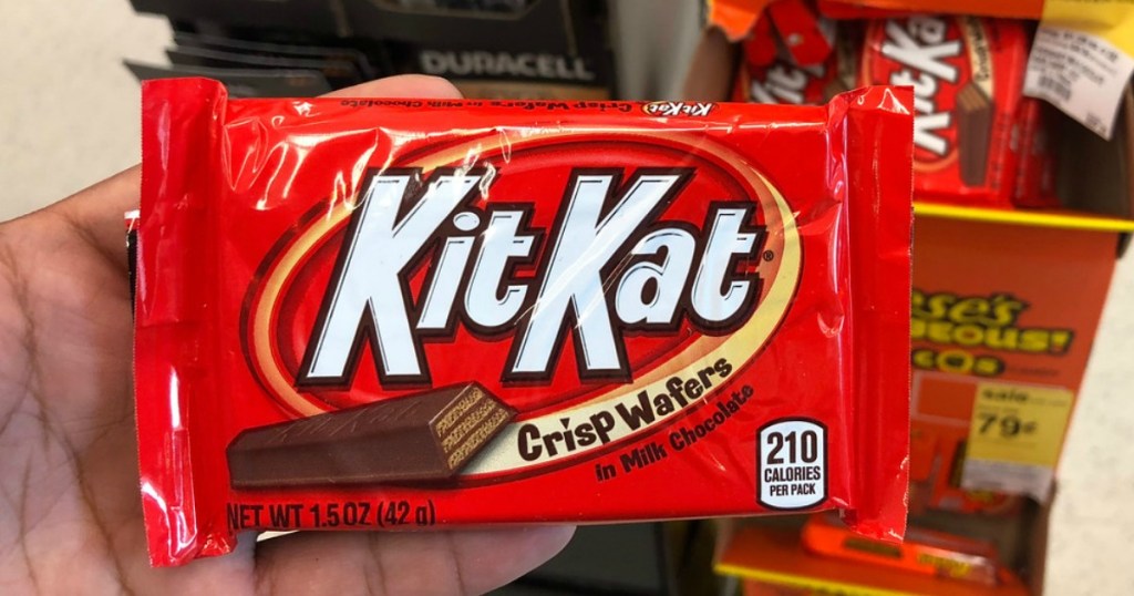hand holding kit kat candy bar in a store