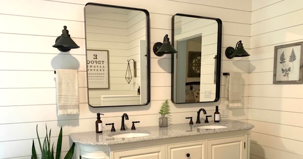 black wall mirrors hanging on white shiplap in bathroom