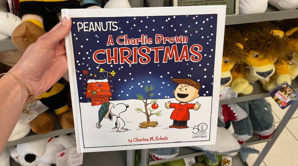 a hand holding the A Charlie Brown Christmas book