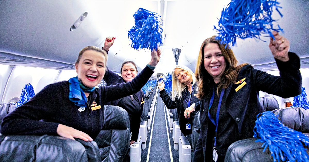 Alaska Airlines flight attendants with pom poms in plane