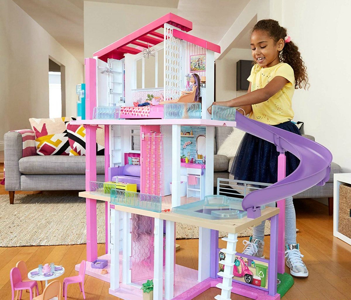 girl playing with Barbie dream house