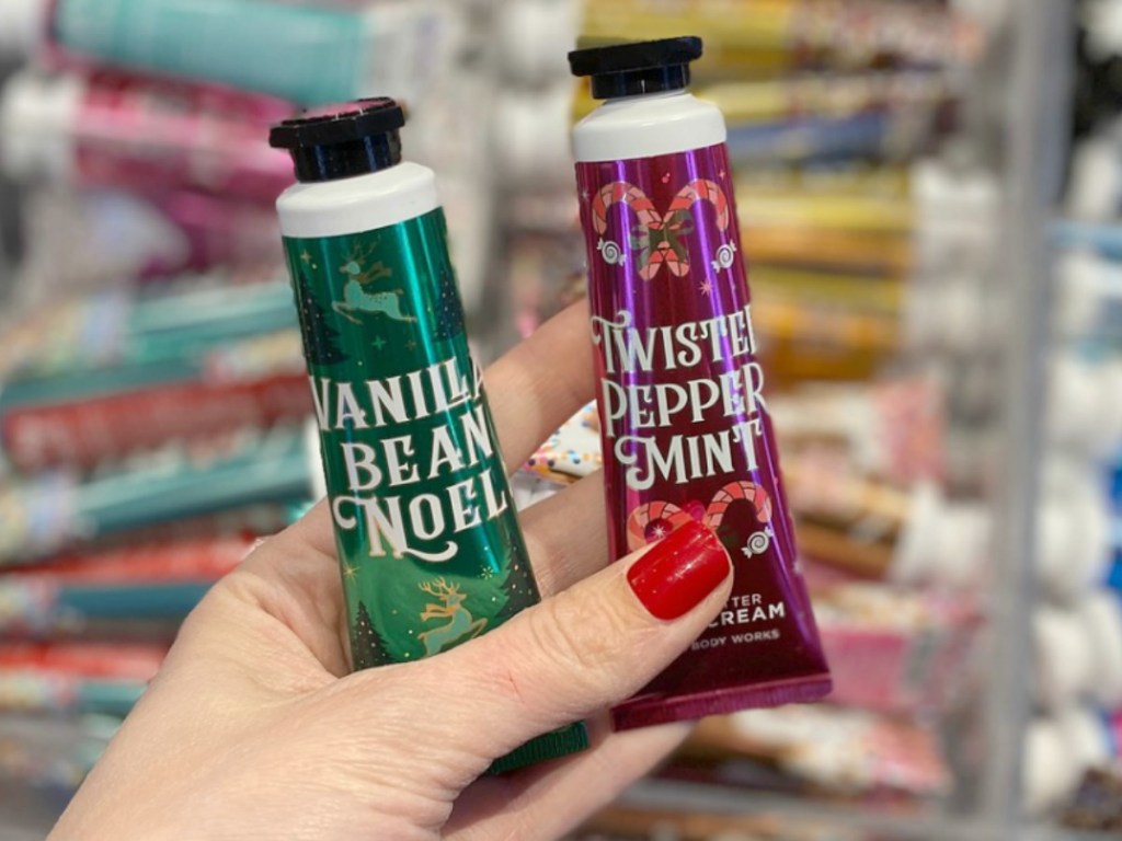 Hand holding two varieties of Bath & Body Works Hand Cream