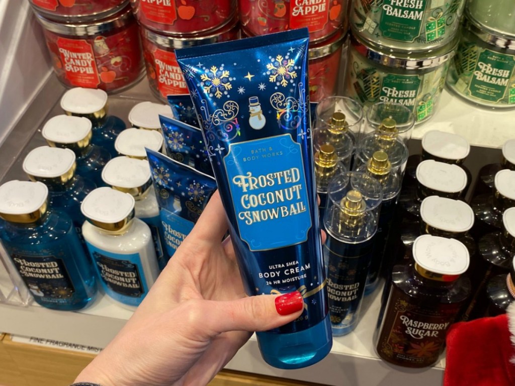 woman holding a Tube of holiday scented body lotion in hand