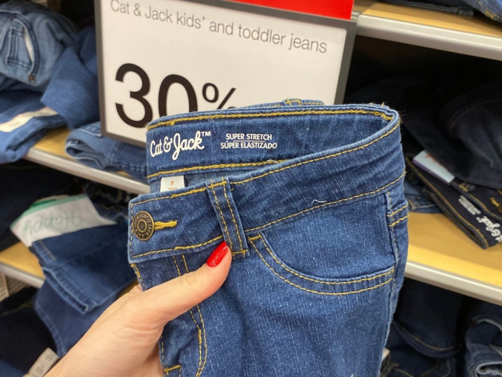 Hand holding Cat & Jack Kids jeans at Target 