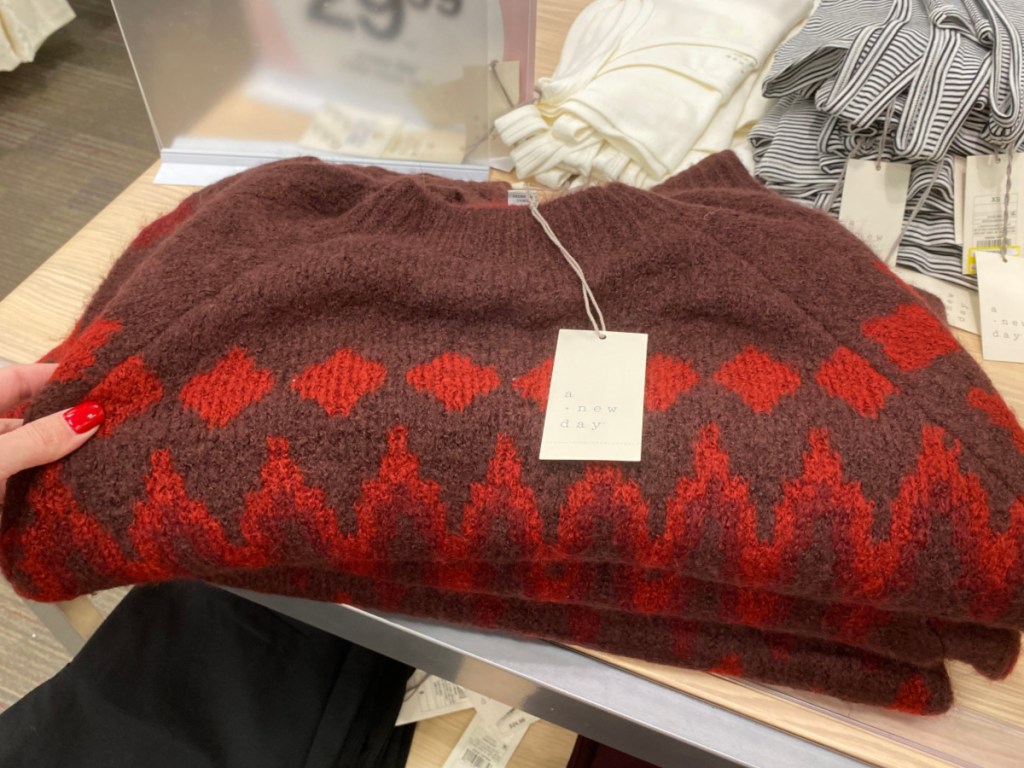 Hand holding women's sweater at Target 