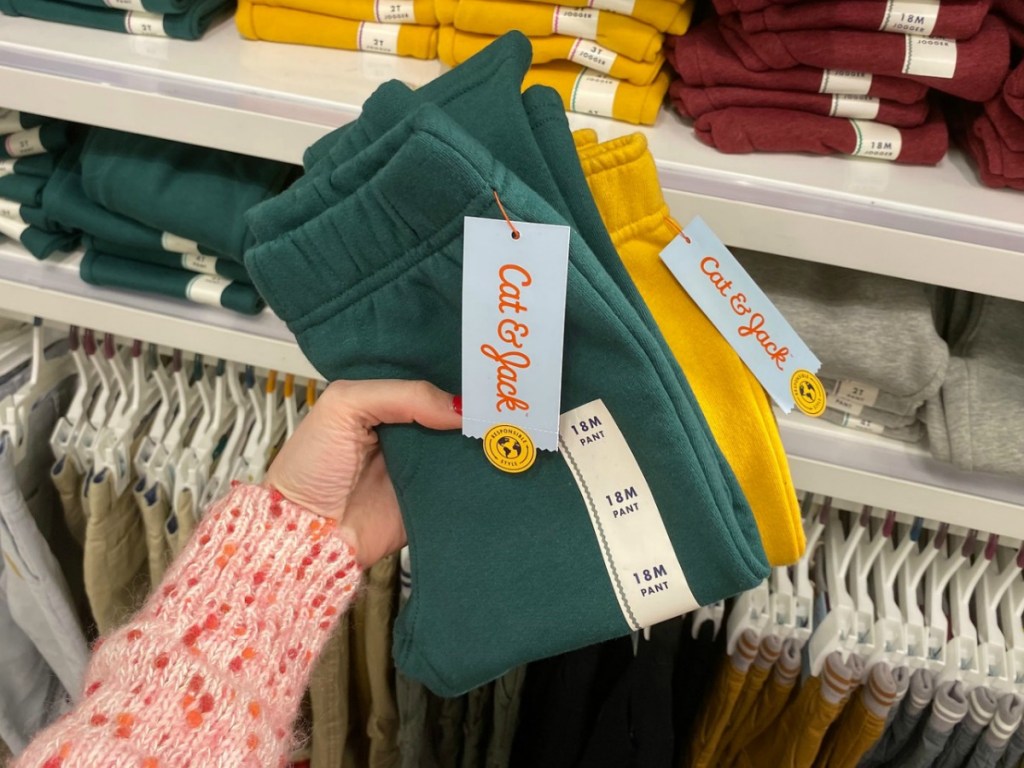 Two pairs of toddler boys pants in store near display