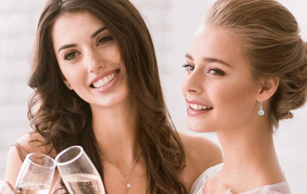 woman toasting and wearing Cate & Chloe Alessandra 18k White Gold Earrings earrings