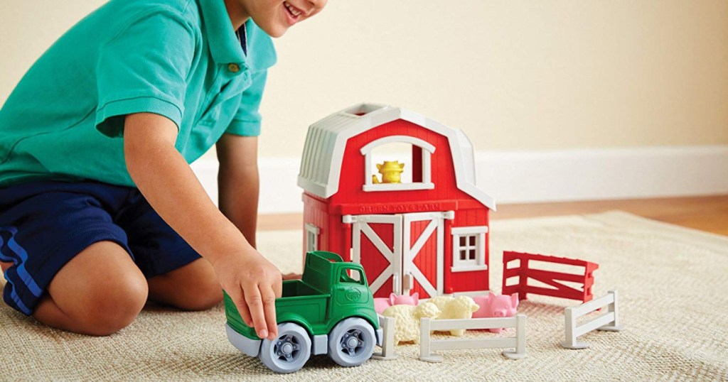 boy playing with green toys farm playset