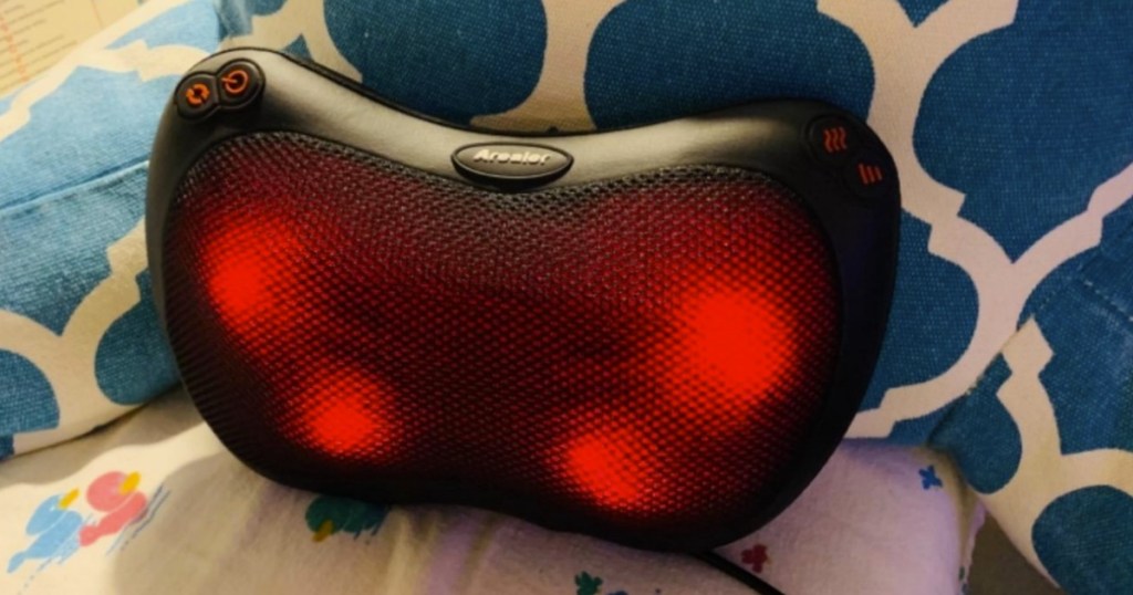 heated head and neck massager on pillow on bed