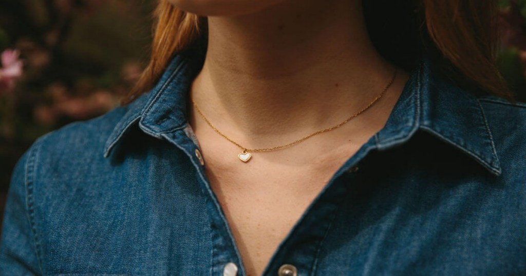 A woman wearing a heart Pendant necklace, with jean shirt