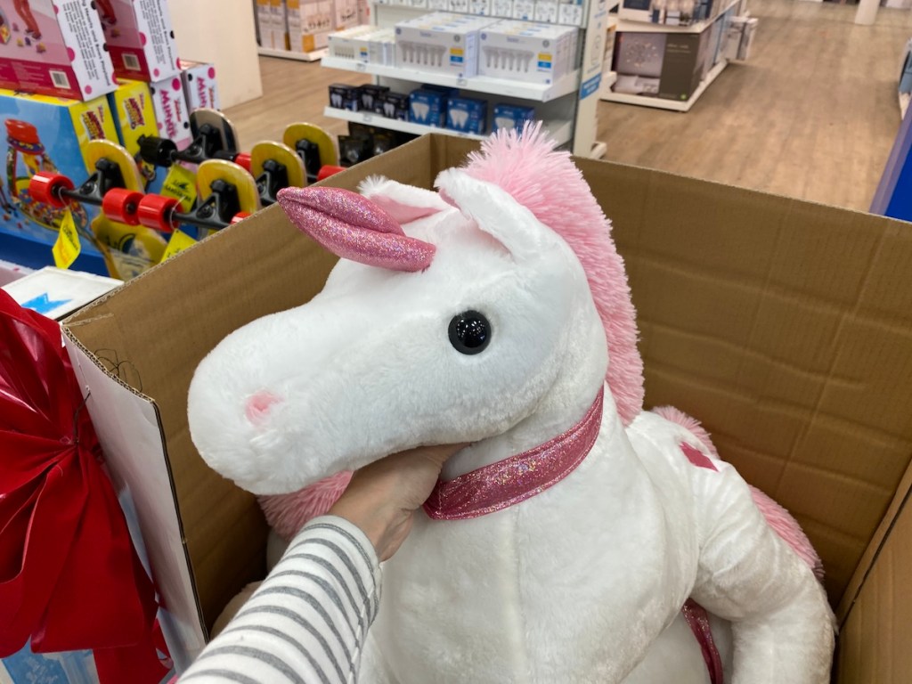 hand holding a HearthSong Dazzle the Plush Unicorn