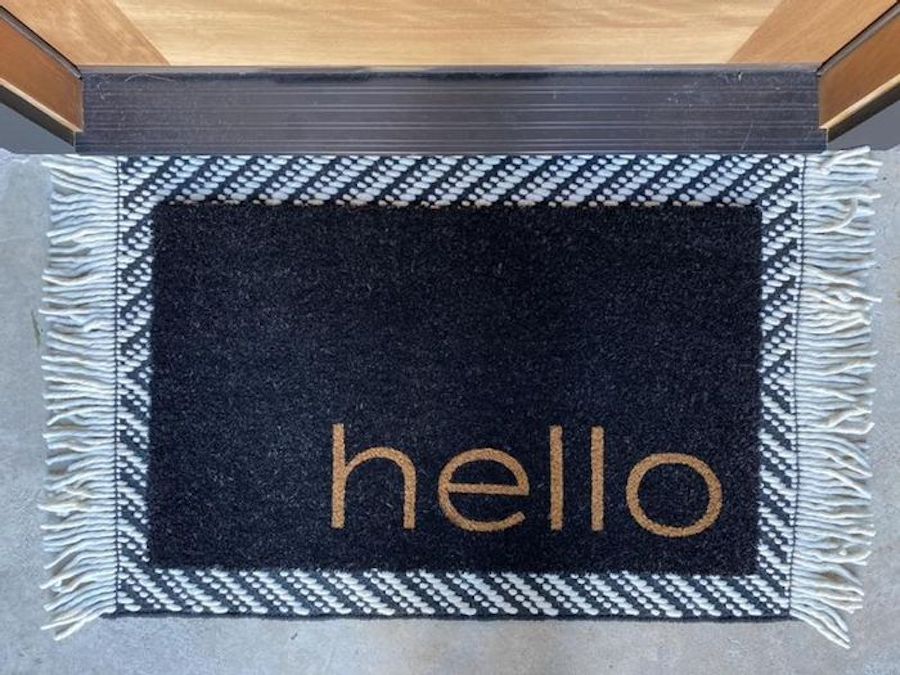 Hello Doormat on black striped rug