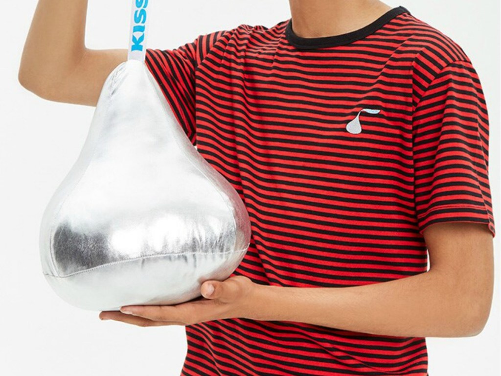 Boy wearing a Hershey's kiss themed shirt holding a pillow
