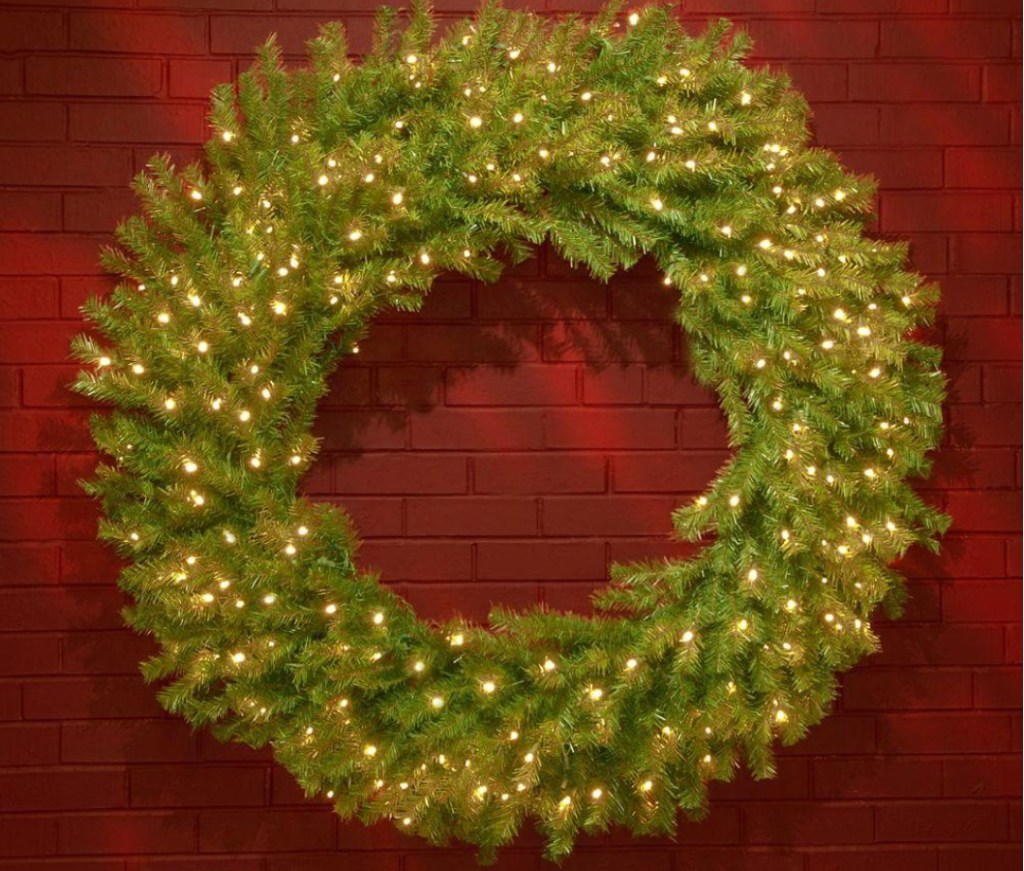 lighted wreath on red brick wall